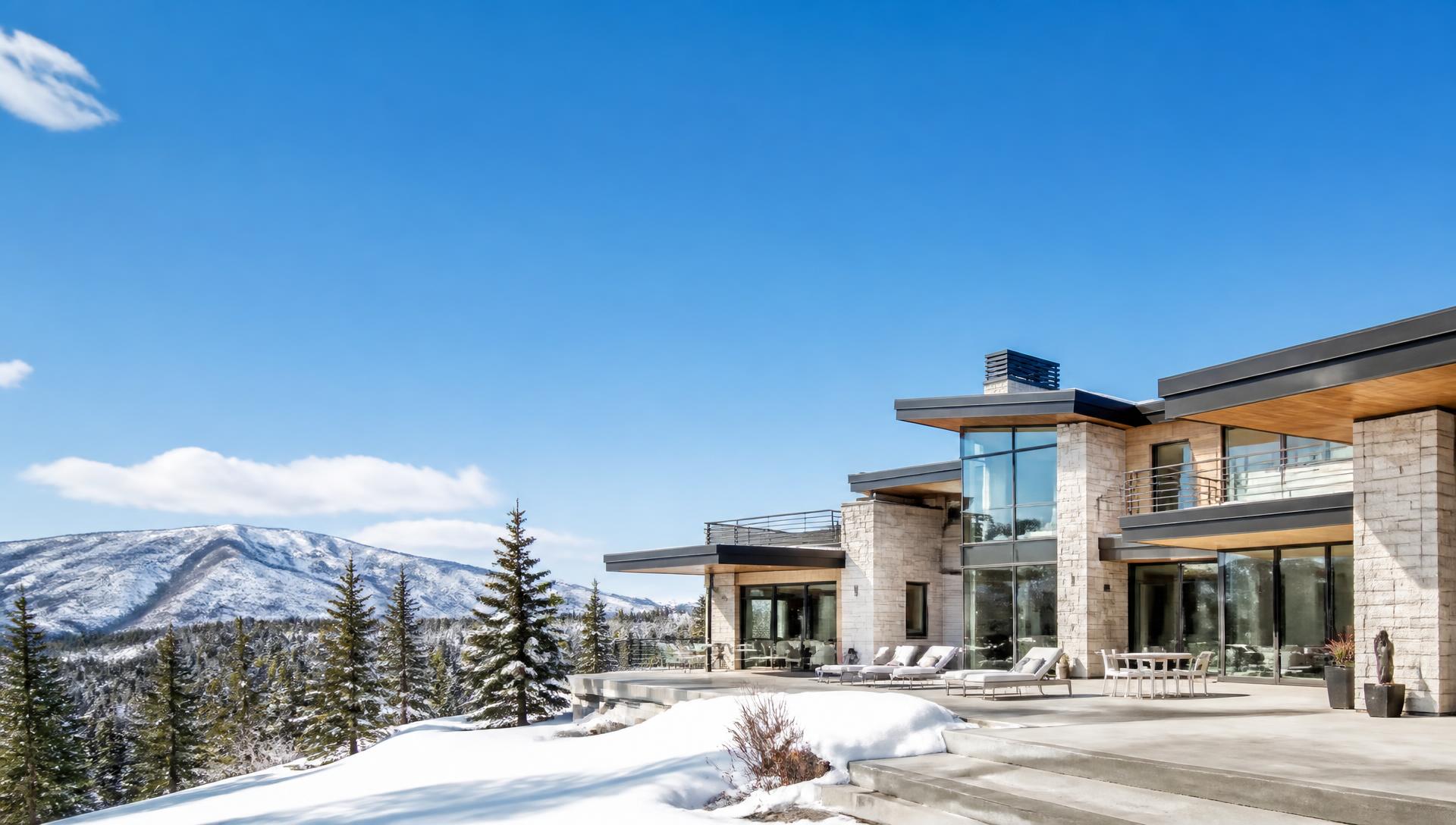 Luxury Park City mountain estate with warm lit interiors below snow-capped Wasatch peaks